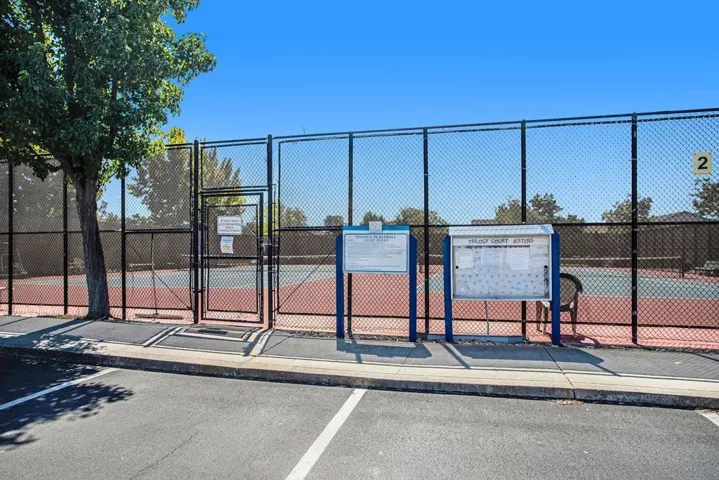 View of tennis court featuring a gate