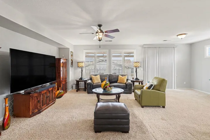 Living room featuring light colored carpet and ceiling fan