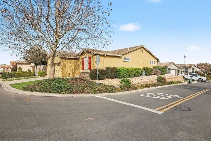 View of front of property featuring stucco siding, a tiled roof, and a residential view
