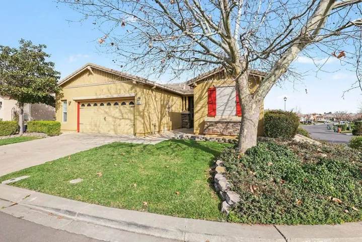 Single story home featuring stucco siding, driveway, a front lawn, and a garage