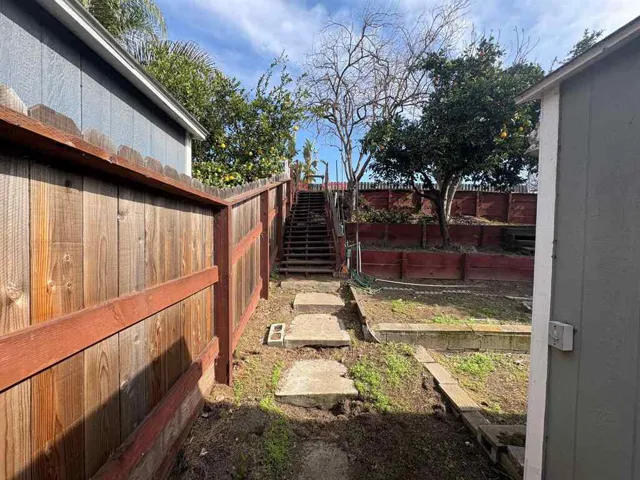 Fenced backyard with stairway