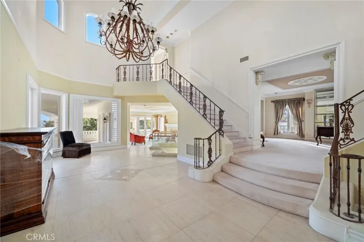 Grand entry with separate staircases to living room and ancillary bedrooms
