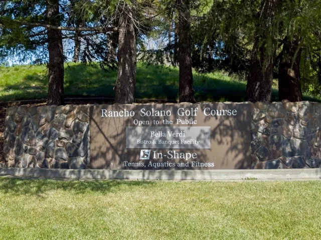 Community / neighborhood sign featuring a lawn