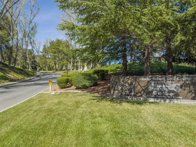 View of asphalt road featuring view of wooded area