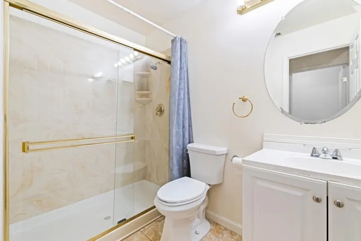 Full bathroom featuring vanity, a shower stall, and light tile patterned floors
