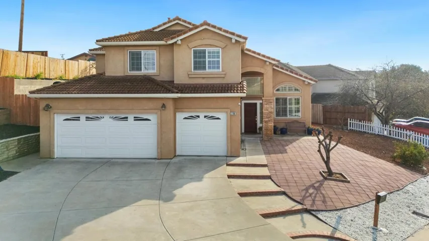 View of front of home with an attached garage, stucco siding, driveway, and a tile roof