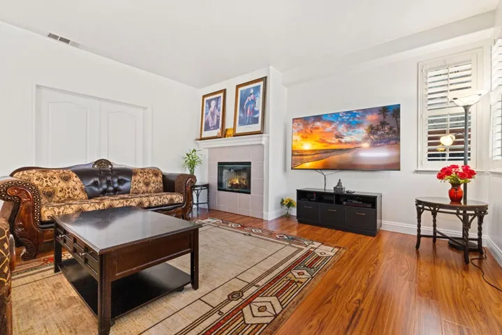 Living area featuring a tiled fireplace and wood finished floors
