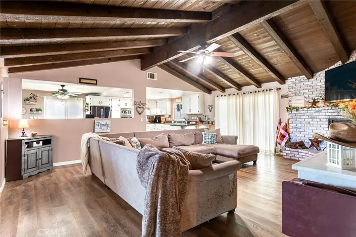 Inviting family room with vaulted ceilings accented by exposed wood beams, creating warmth and architectural character.