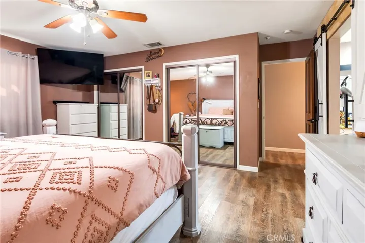Primary bedroom offers mirrored closet doors, luxury vinyl plank flooring, and a generous, flexible layout.