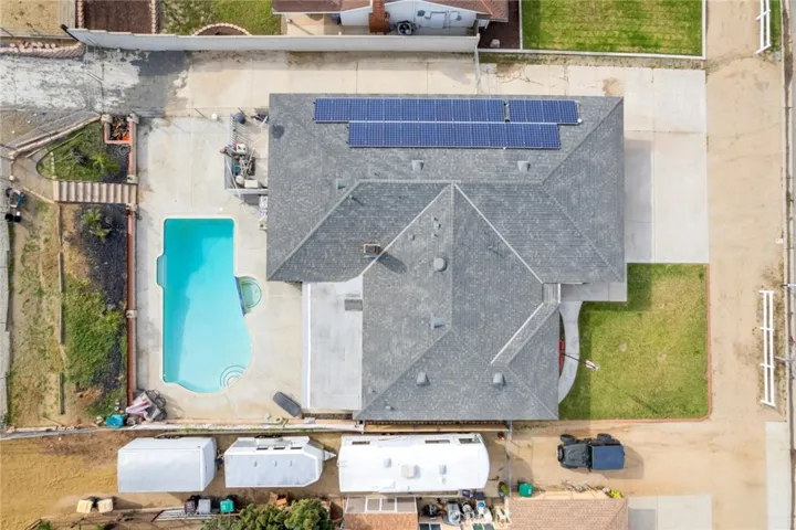 Overhead view highlighting the expansive RV parking area with concrete access, ideal for RVs, trailers, and recreational vehicles, alongside a private backyard with pool and solar-equipped home. Soalr is paid off.