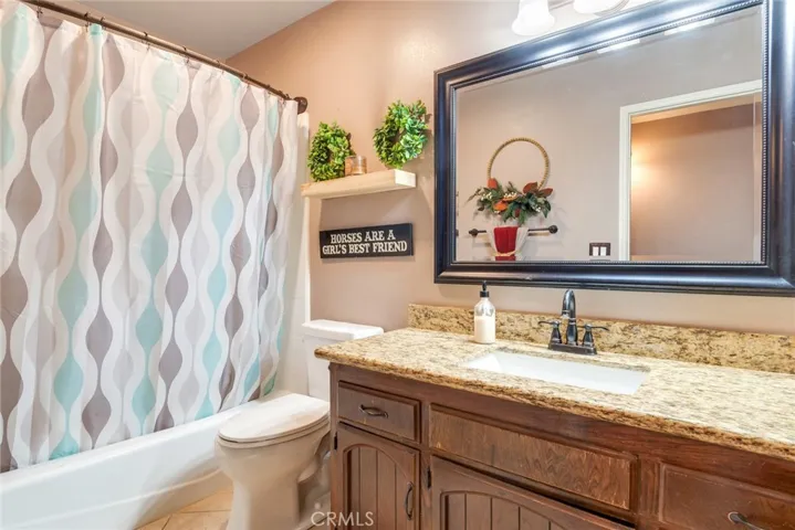 Guest bathroom featuring a tub/shower combination and granite countertop vanity.
Warm finishes and functional layout ideal for everyday use or guests.