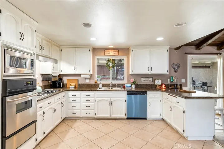 Spacious kitchen featuring white cabinetry, a brand-new dishwasher, and a backyard-facing window overlooking the pool and patio.
A light-filled space that connects seamlessly to indoor-outdoor living.