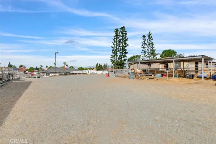 Well-laid-out equestrian space with four stalls and open ground ideal for a round pen.