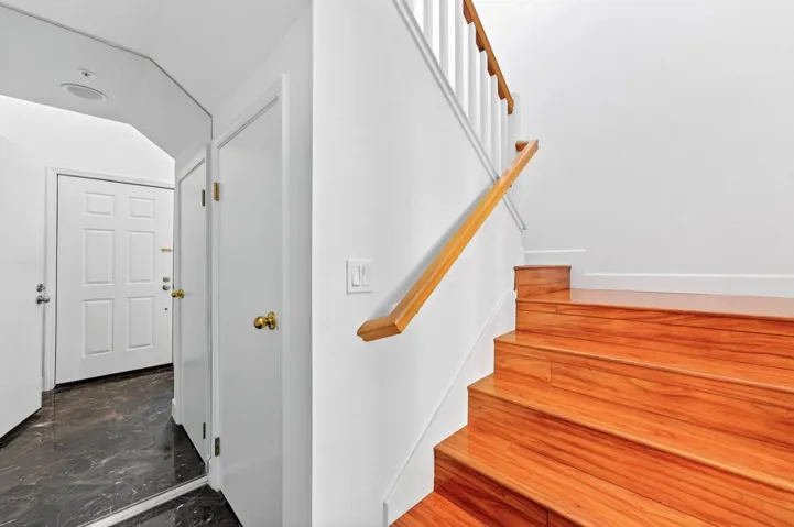 Stairs featuring marble tiled floors and baseboards