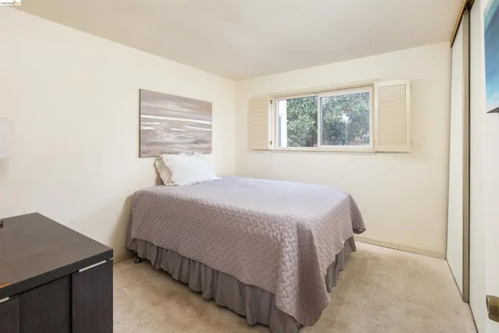 Bedroom featuring light carpet and baseboards