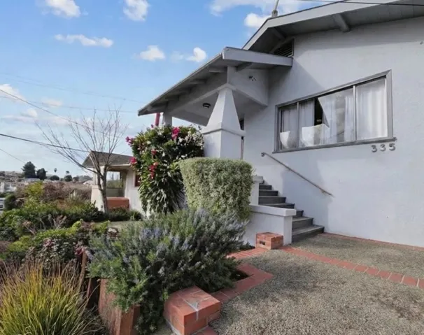 View of side of property with stucco siding and stairway