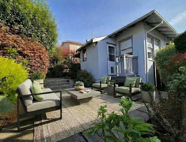 View of property exterior with outdoor lounge area, stucco siding, and a patio