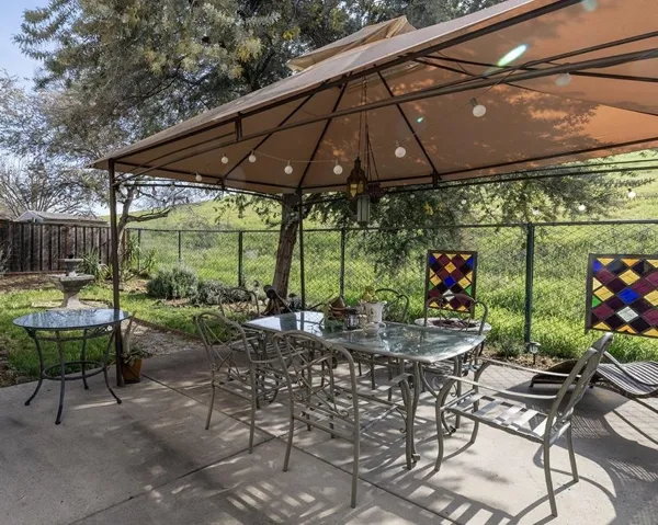 Fenced backyard with outdoor dining space, a patio area, and a gazebo