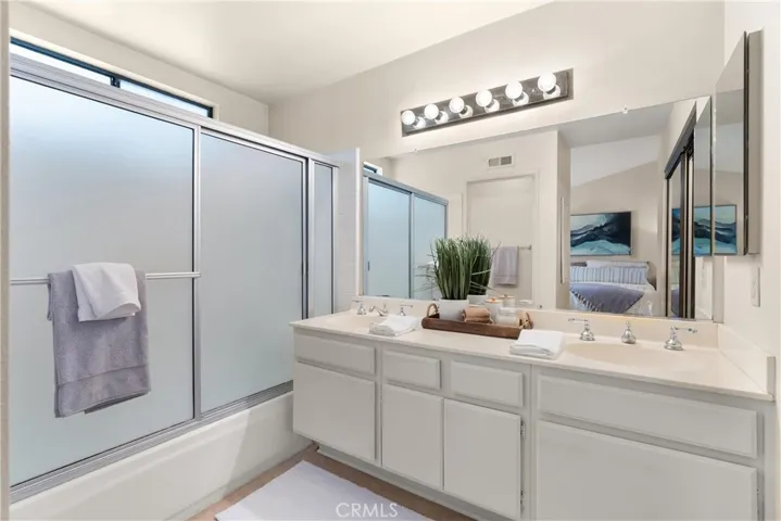 Double sinks and shower over tub.