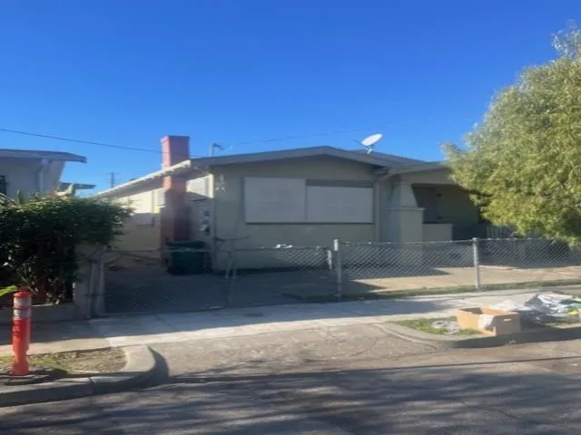 View of front facade with a fenced front yard, a gate, and a chimney