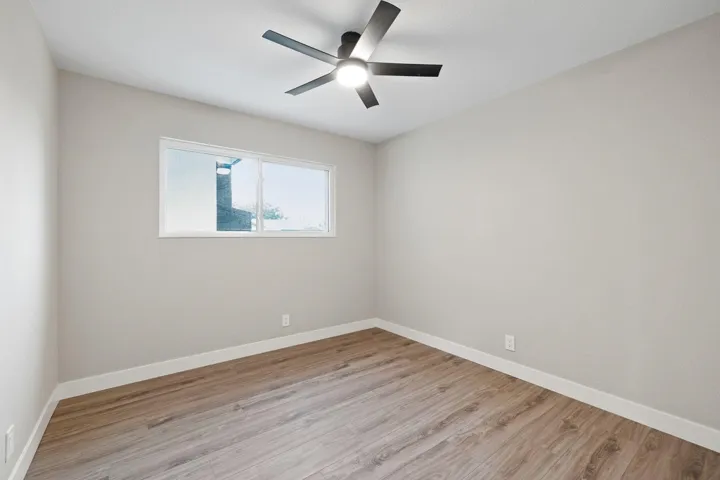 Unfurnished room featuring light wood-style floors and ceiling fan