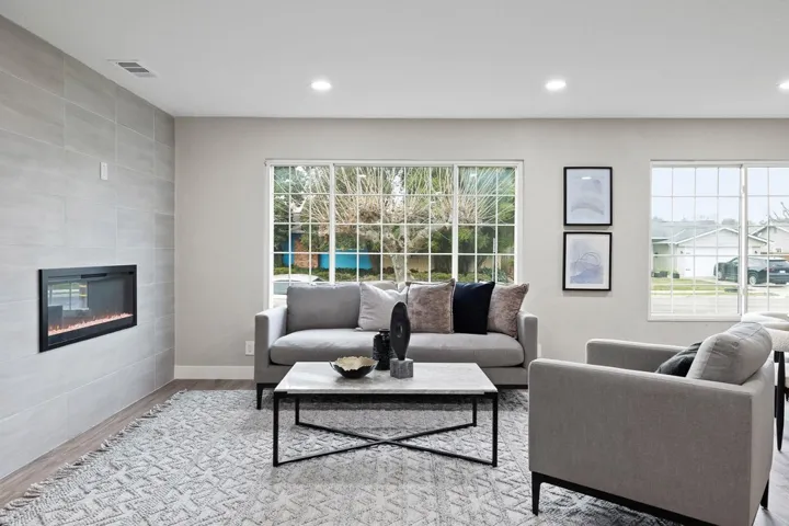 Living room featuring wood finished floors, a tiled fireplace, tile walls, and recessed lighting