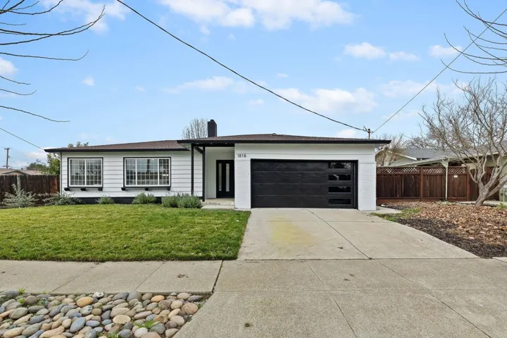 View of front of house with concrete driveway, an attached garage, brick siding, and a shingled roof