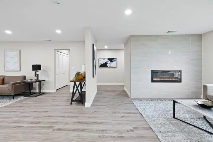 Living room featuring a fireplace, light wood-style flooring, and recessed lighting