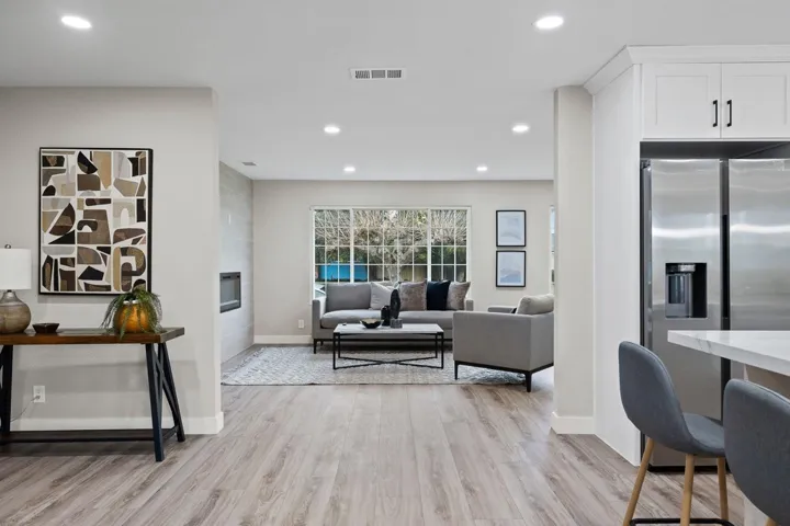 Living room featuring light wood-type flooring, recessed lighting, and a fireplace