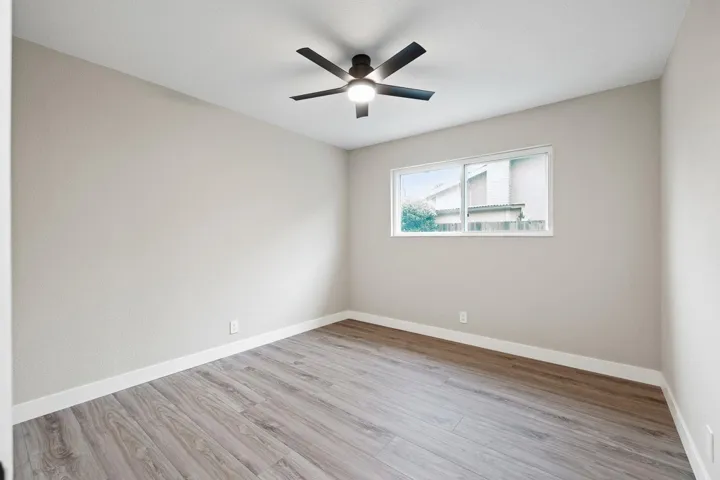 Empty room featuring light wood finished floors and ceiling fan