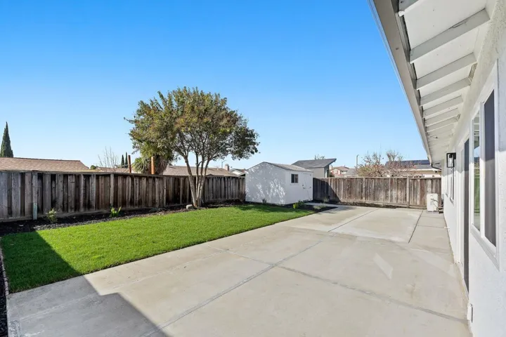 Fenced backyard with a patio area and a storage shed