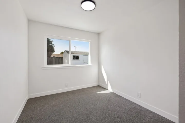 Carpeted spare room with baseboards