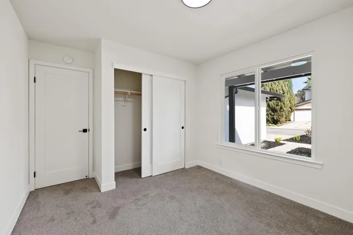 Unfurnished bedroom featuring light carpet and a closet