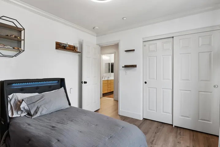 Bedroom featuring crown molding, a closet, and light wood-type flooring