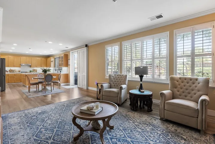 Living room with dark wood-type flooring, crown molding, and recessed lighting
