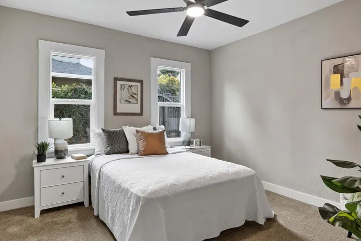 Bedroom featuring a ceiling fan, carpet flooring, and a textured wall