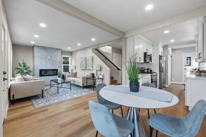 Dining area featuring stairs, light wood-style flooring, recessed lighting, and a large fireplace