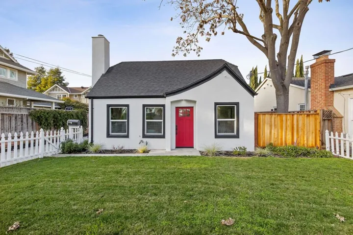 View of front of property with a chimney, stucco siding, and a shingled roof
