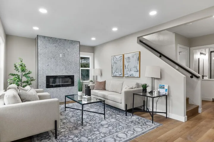 Living area with stairs, wood finished floors, recessed lighting, and a tile fireplace