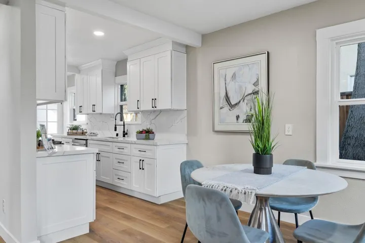 Kitchen featuring white cabinetry, light wood-style floors, light stone countertops, beam ceiling, and recessed lighting
