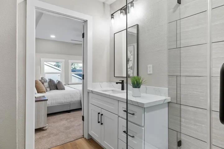 Ensuite bathroom featuring vanity, light wood finished floors, a textured wall, and recessed lighting