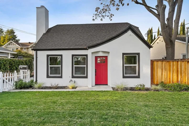 View of front of home with a chimney, roof with shingles, and stucco siding