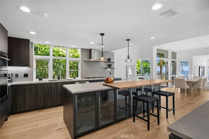 The designer kitchen is both refined and functional, showcasing porcelain countertops, custom cabinetry, and premium Sub-Zero and Thermador appliances ideal for both everyday living and stylish entertaining.