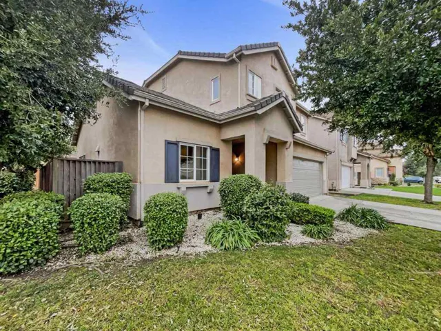 Traditional-style home with stucco siding, driveway, and a garage