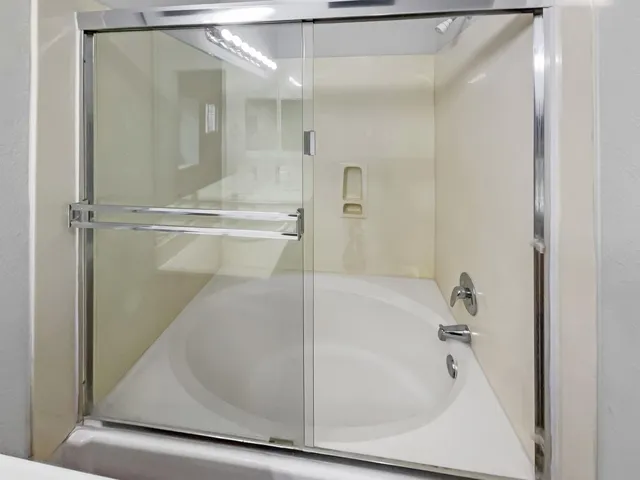 Bathroom featuring a shower with shower door and a tub to relax in