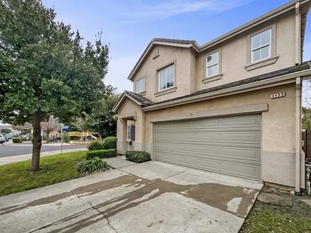 Traditional-style house featuring stucco siding, driveway, and a garage