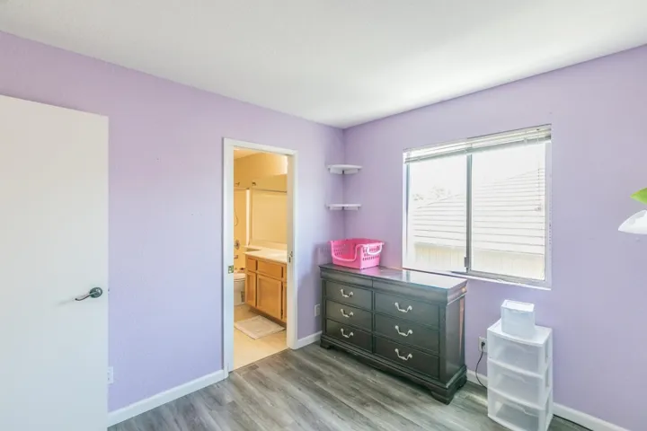 Bedroom featuring light wood-style floors and connected bathroom