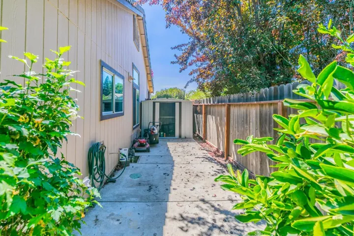 View of side of property featuring a fenced backyard and a storage shed