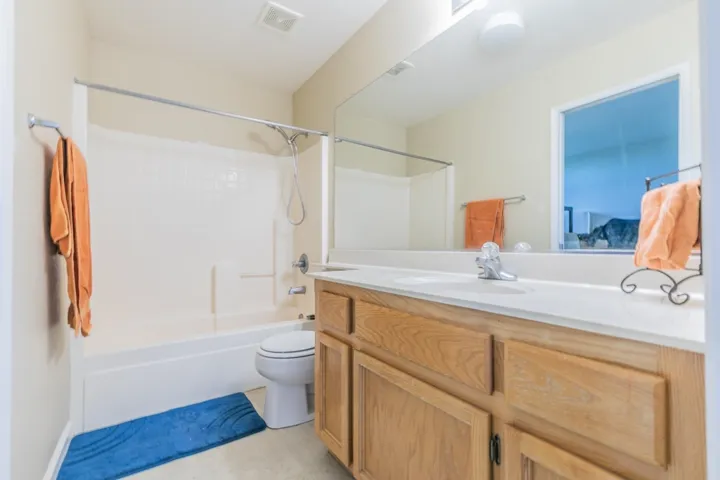 Full bathroom with vanity, bathing tub / shower combination, and light tile patterned flooring