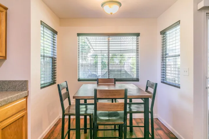Dining space with healthy amount of natural light and dark wood-type flooring
